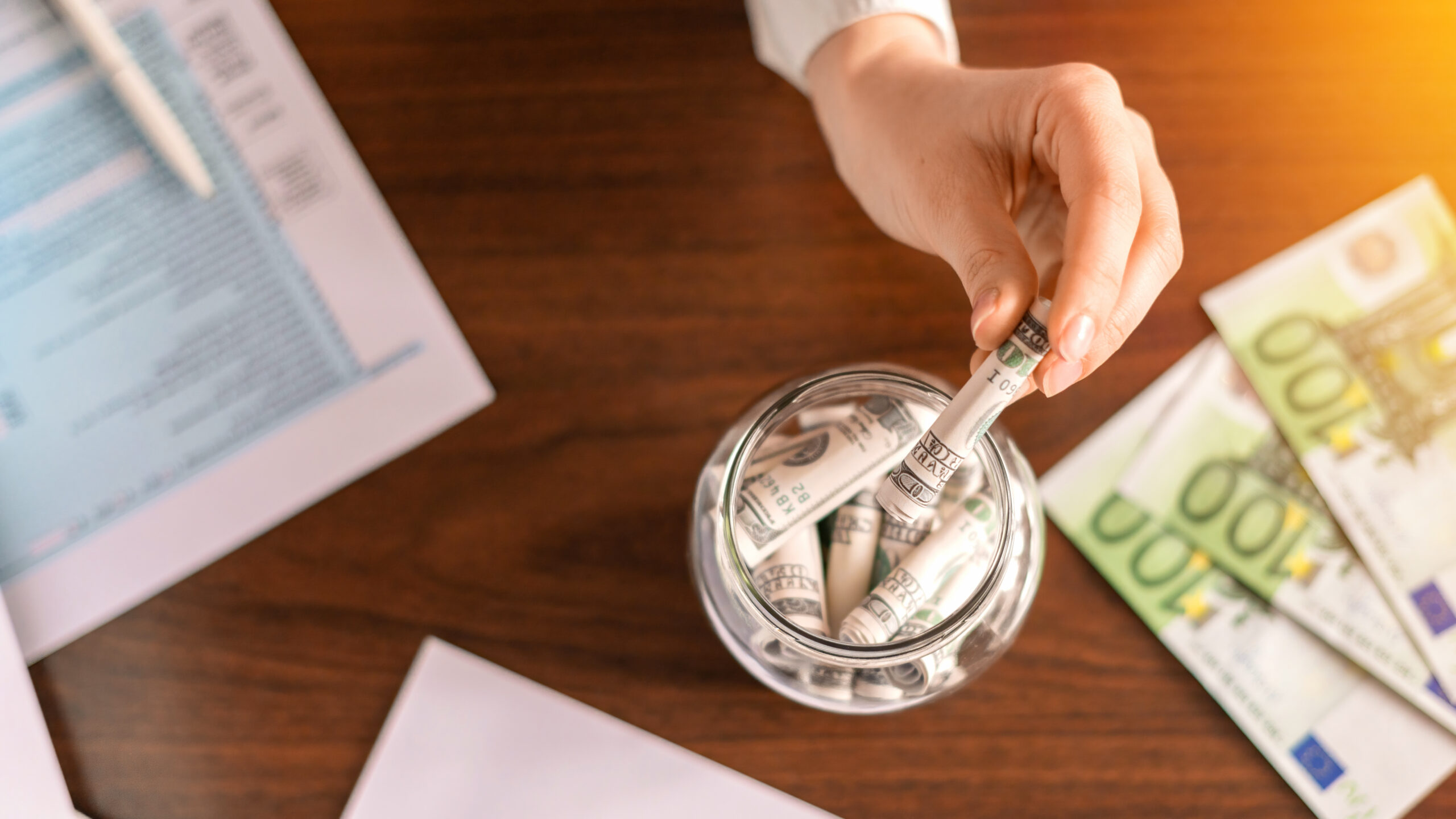 A jar with rolled banknotes on the table